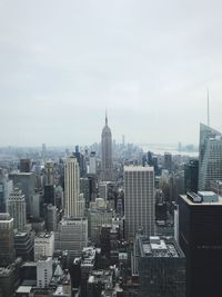 Aerial view of buildings in city against sky