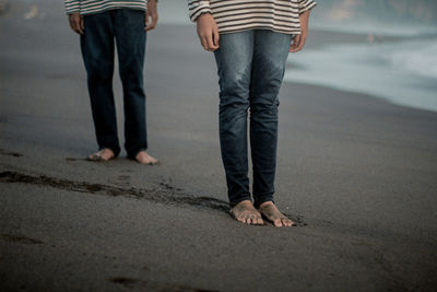 Low section of people standing at beach