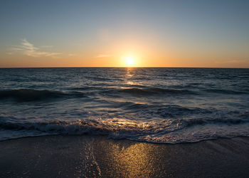 Scenic view of sea against dramatic sky during sunset