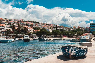 Boats moored in sea against buildings in city