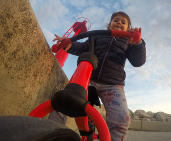 Low angle portrait of smiling boy against sky during winter