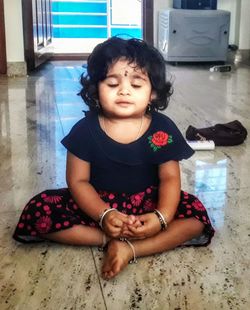 Cute girl sitting on floor at home