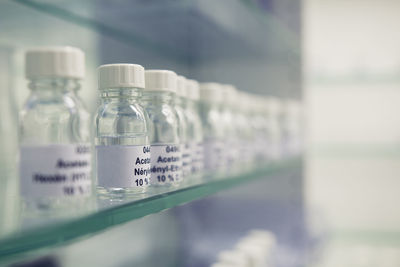 Close-up of bottles with text on shelf at laboratory