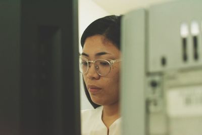 Close-up of serious young woman working in office