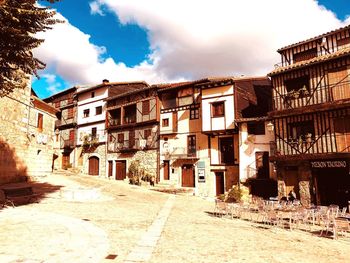 Street amidst buildings in city against sky