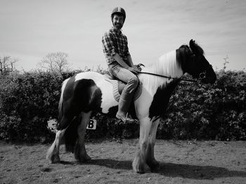 Portrait of man riding horse on footpath