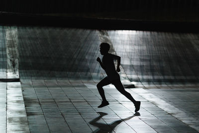 Full length of silhouette man running on footpath