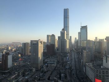 Aerial view of buildings in city against clear sky