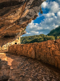 Rock formations on mountain against cloudy sky