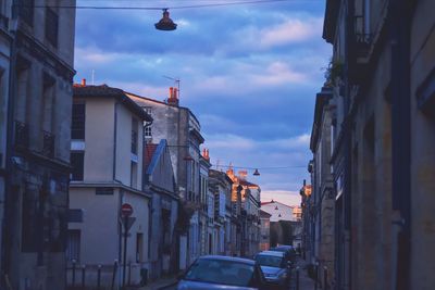 Traffic on road amidst buildings against sky