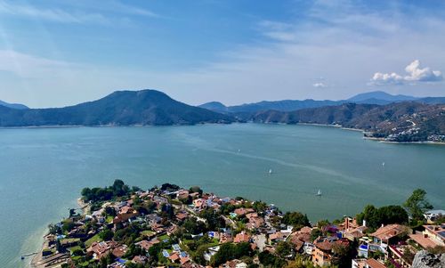Scenic view of sea by town against sky
