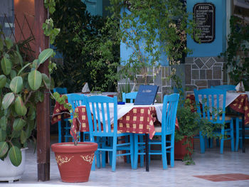 Empty chairs and tables against building