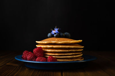 Close-up of cake on table against black background