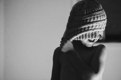 Shirtless boy wearing knit hat at home