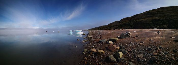 Scenic view of rocks on beach against sky