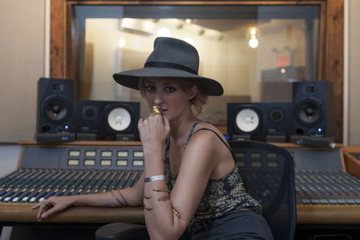 Portrait of woman wearing hat sitting in kitchen