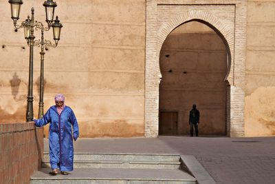 Man standing by wall of building