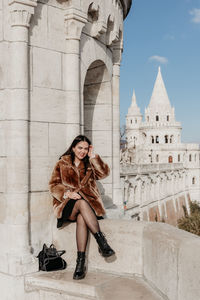 Stylish young woman standing on balcony at fisherman's bastion in budapest, hunagry