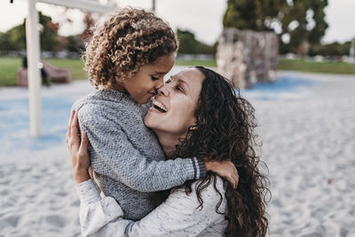 Close up of happy mother and son embracing closely on playground