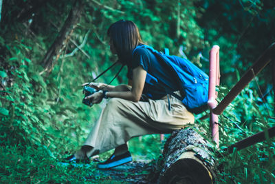 Rear view of man sitting in forest