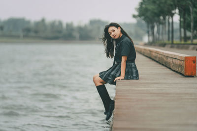 Damsel in uniform by a lake on a cloudy day