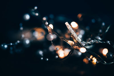 Close-up of illuminated guitar against black background