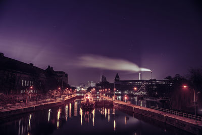 Illuminated bridge over river against sky at night