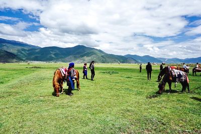 People enjoying on field against sky