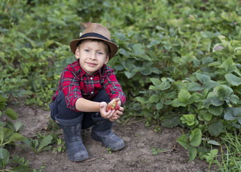 Portrait of boy standing amidst plants