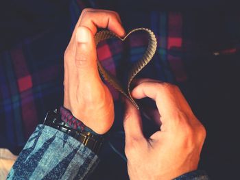 Cropped hands of man making heart shape with paper