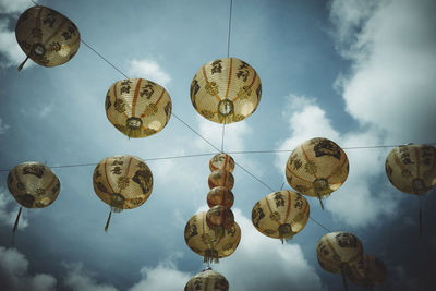 Low angle view of lanterns hanging against sky