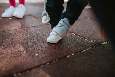 Low section of woman standing on footpath