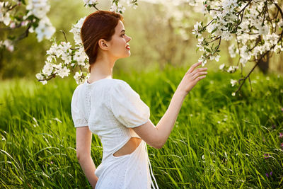 Young woman standing amidst flowers