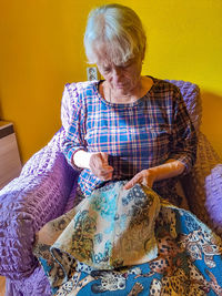 Rear view of woman sitting on sofa at home