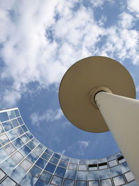 Low angle view of modern building against cloudy sky