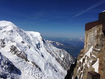 Scenic view of snowcapped mountains against blue sky