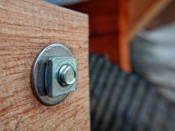 Close-up view of threaded bolts made of white metal, driven into the body of the board