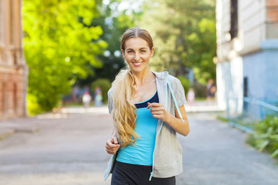 Portrait of smiling young woman standing on street