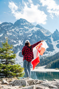 Rear view of woman standing on snow covered mountains