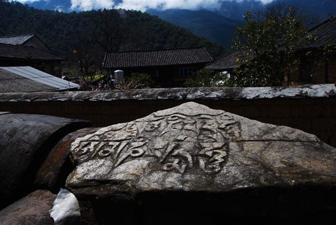 built structure, mountain, architecture, building exterior, tree, sky, mountain range, house, outdoors, no people, day, spirituality, religion, history, travel destinations, old, nature, tranquility, stone material, place of worship