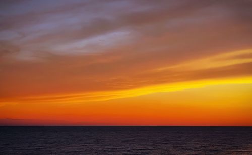 Scenic view of dramatic sky over sea during sunset