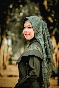 Portrait of smiling young woman standing outdoors