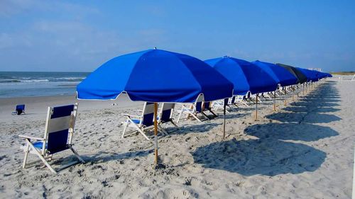 Scenic view of beach against cloudy sky