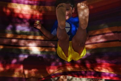 Directly above shot of boy lying in hammock