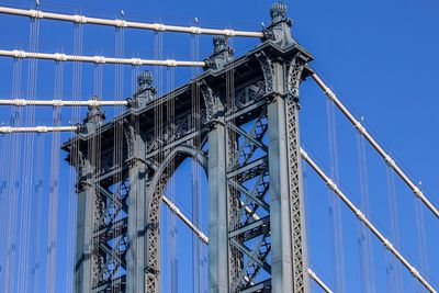 Low angle view of manhattan bridge against blue sky