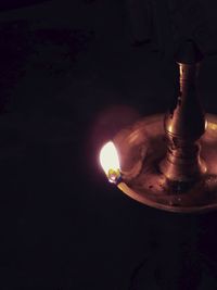 Close-up of illuminated lamp over black background