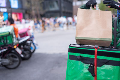 Rear view of woman with suitcase on street