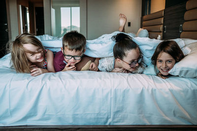 Kids laying on bed in hotel room on vacation