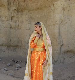 Woman looking away while standing outdoors