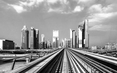 Railroad tracks against cloudy sky
